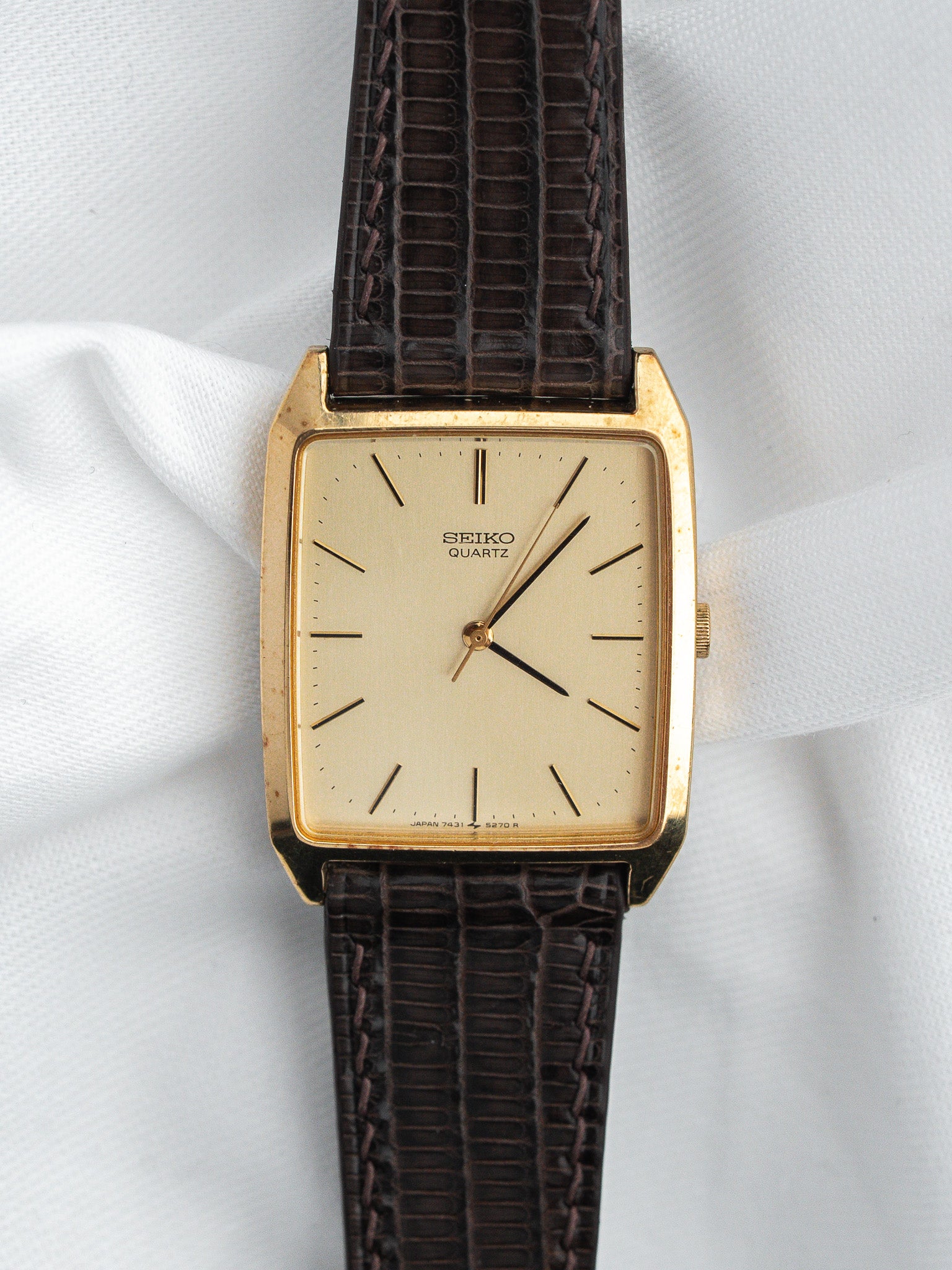 Seiko Quartz vintage watch with gold case, cream dial, and brown textured strap