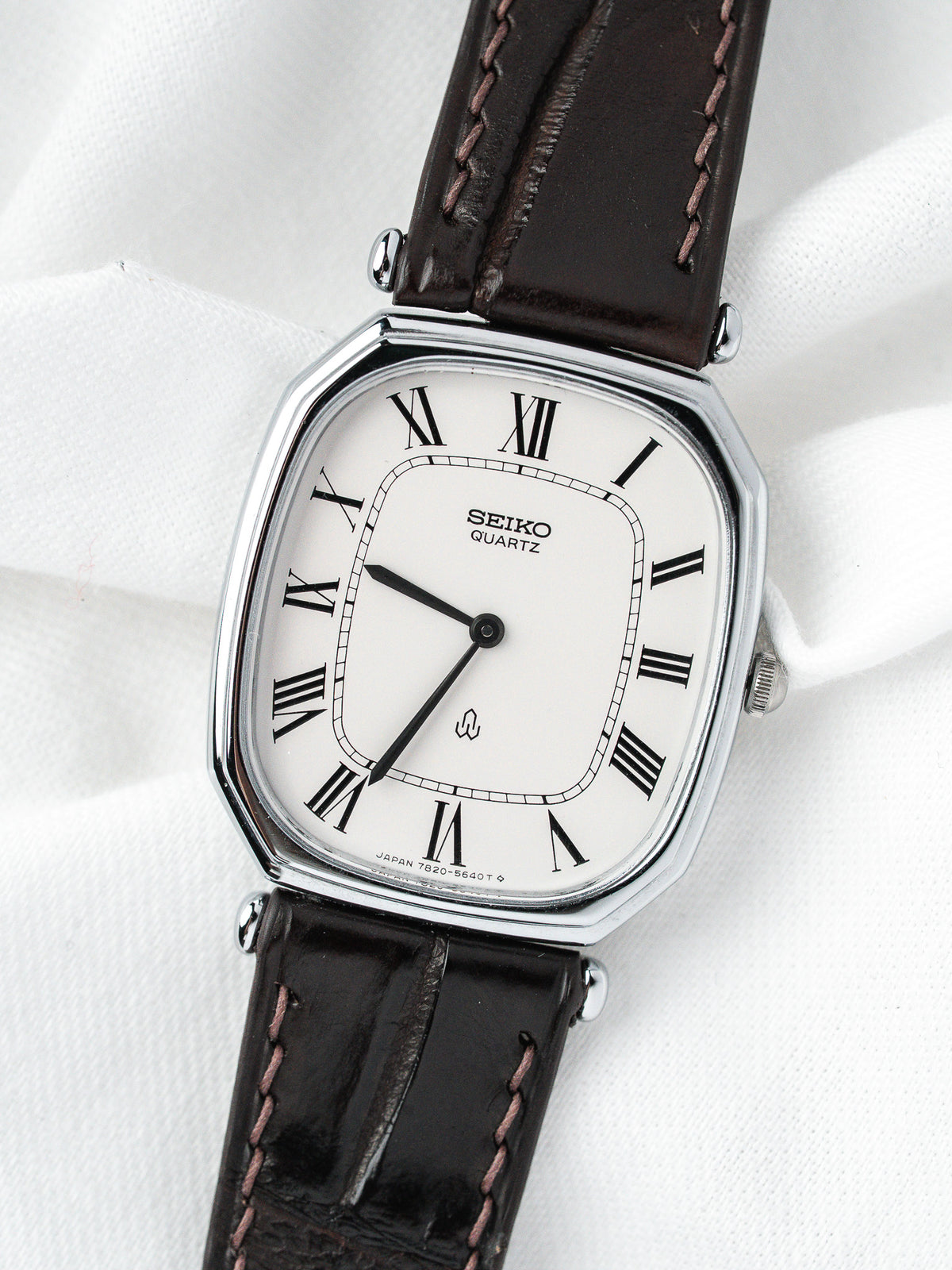 Montre Seiko Quartz vintage, boîtier rectangulaire argenté, cadran blanc et bracelet cuir marron