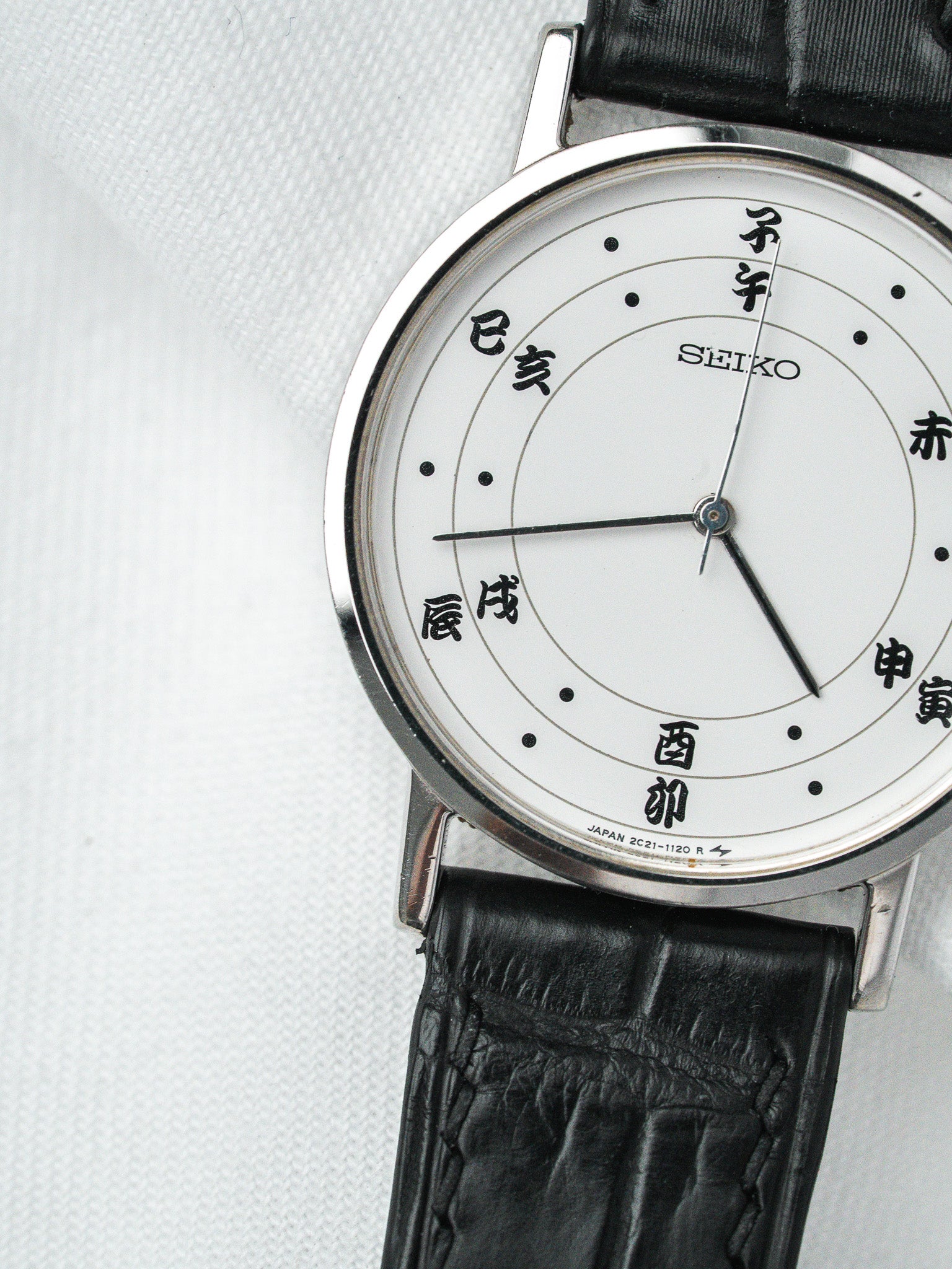 Seiko vintage watch with white dial, black leather strap, and Japanese characters