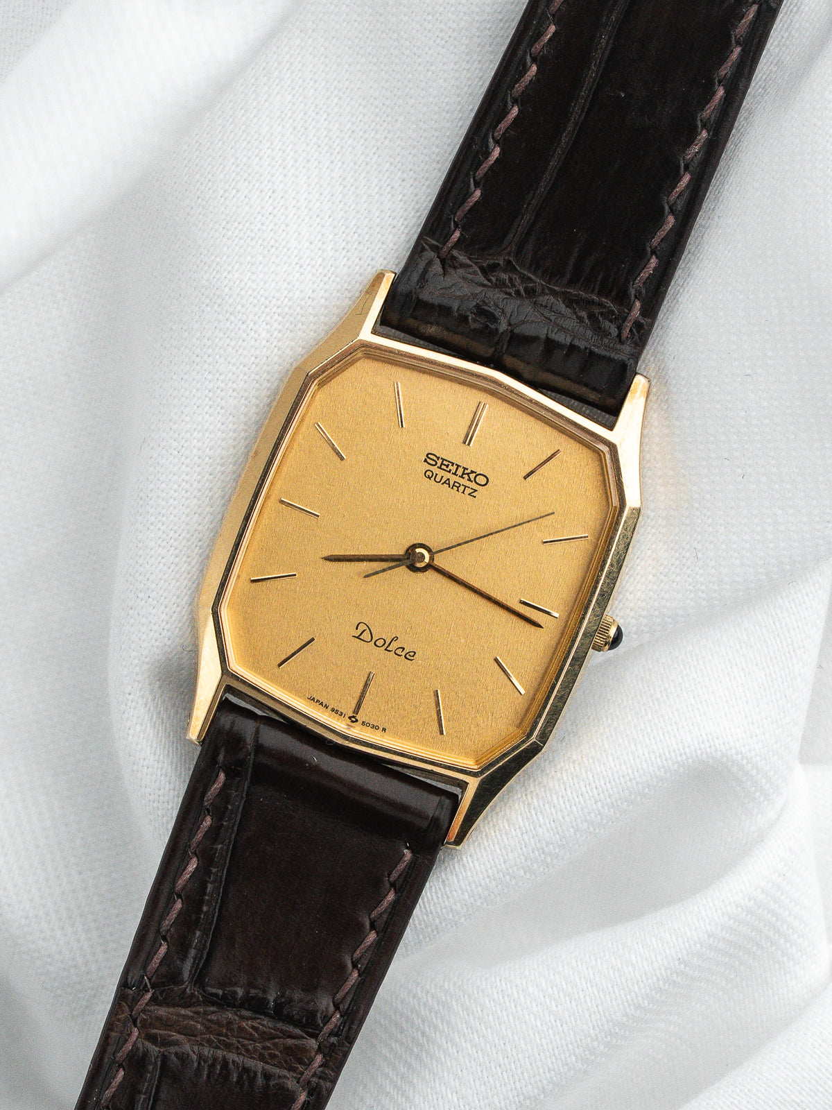 Montre Seiko Dolce vintage, boîtier rectangulaire doré, cadran jaune et bracelet cuir marron