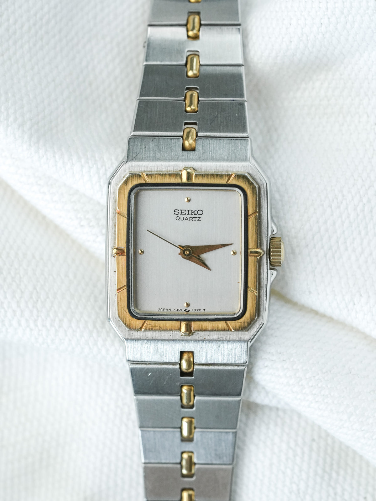Seiko Quartz vintage watch with silver dial, gold accents, and two-tone metal bracelet