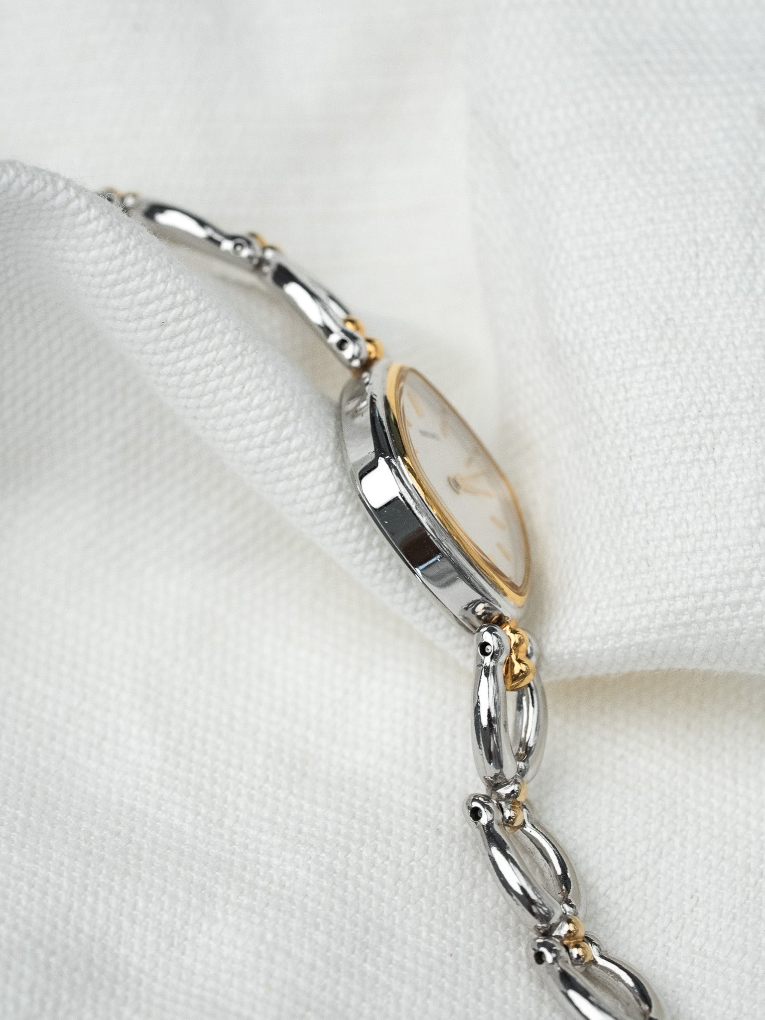 Vintage Omega watch with two-tone bracelet, gold bezel, white dial on fabric