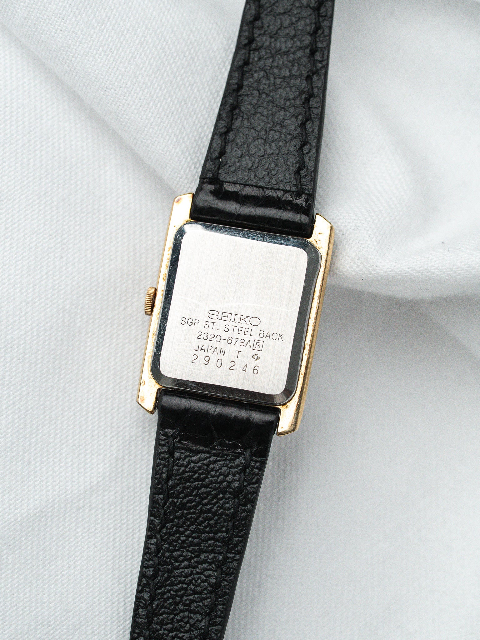 Seiko vintage watch with gold case, black leather strap, steel back engraved