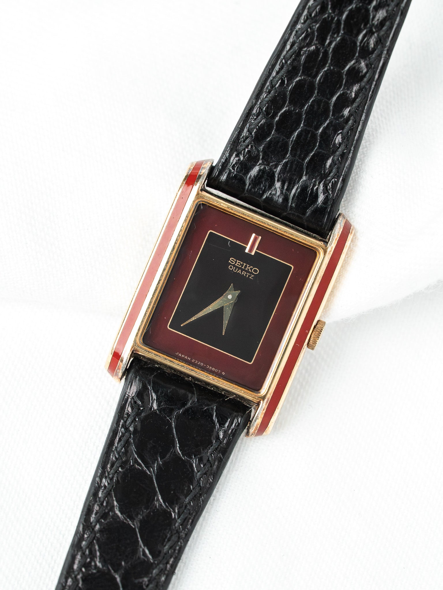 Seiko Quartz vintage watch with red gold case, black dial, and textured black strap