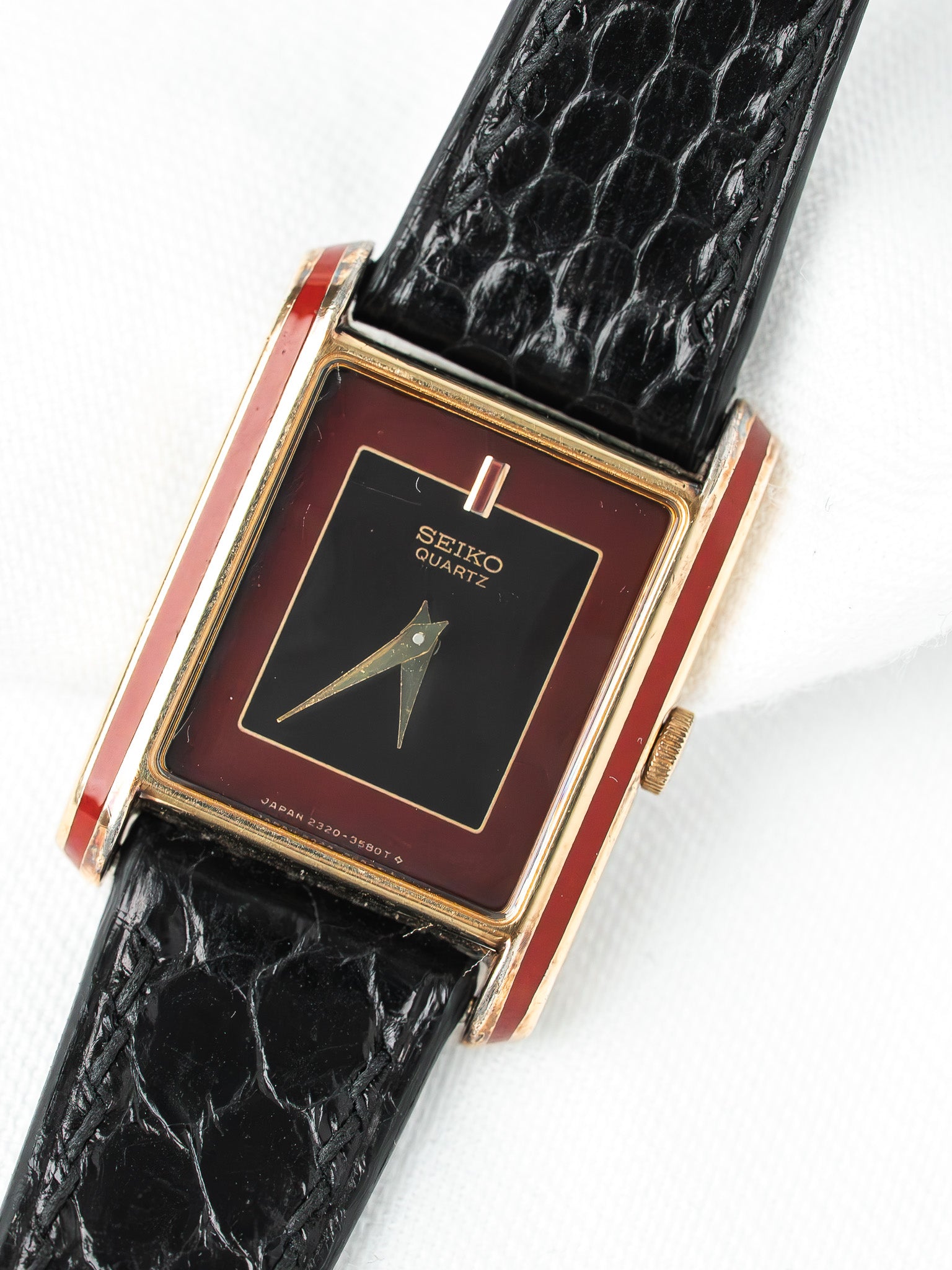 Seiko Quartz vintage watch with black dial, red enamel case, and black alligator strap