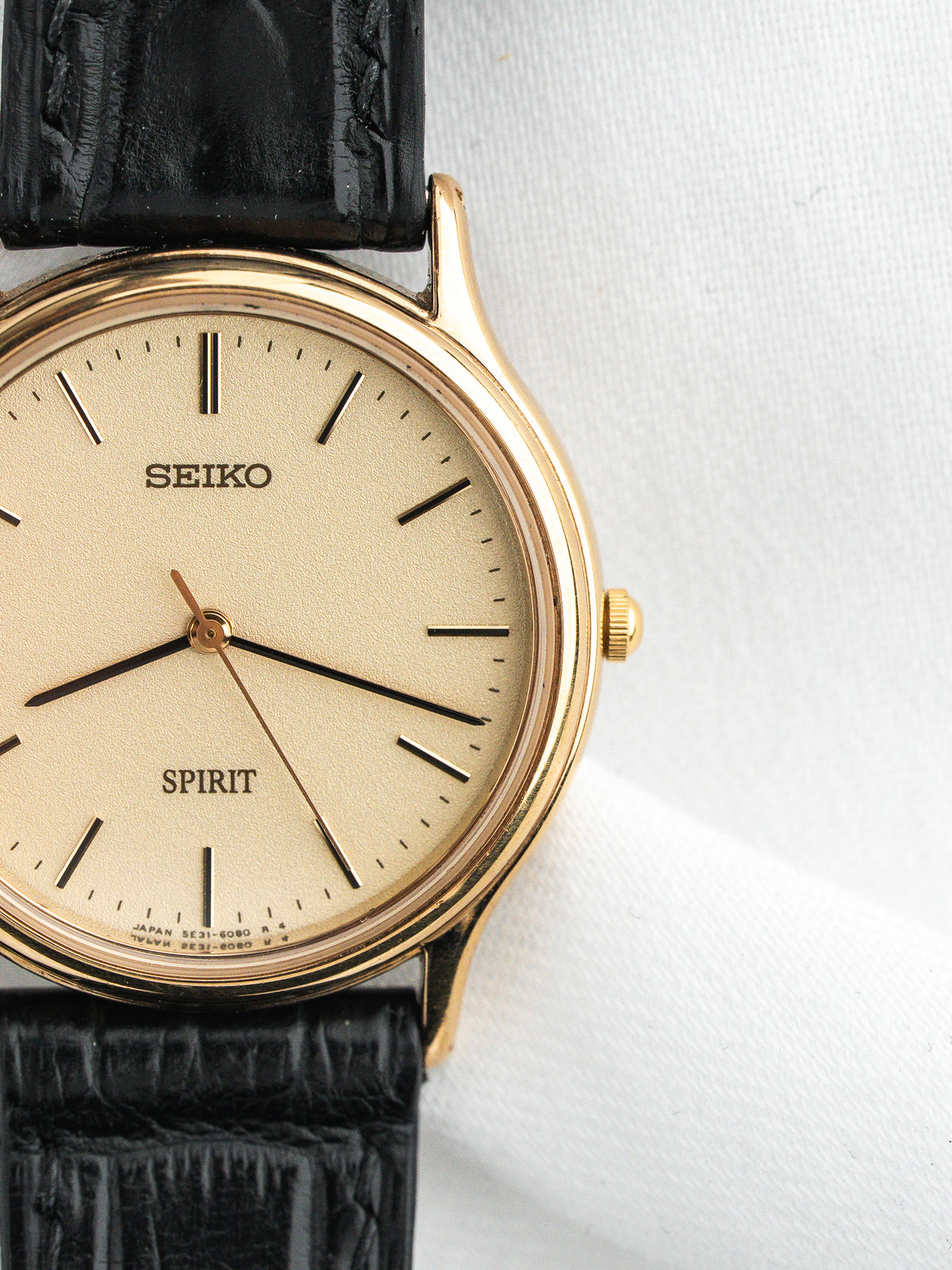 Montre Seiko Spirit vintage, boîtier doré, cadran champagne et bracelet en cuir noir