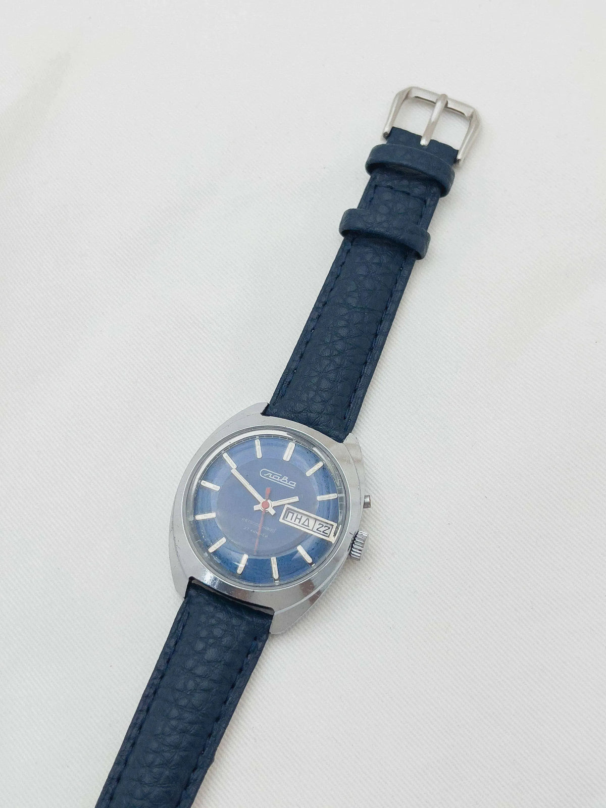 Vintage Slava watch with blue dial, steel case, and dark blue leather strap