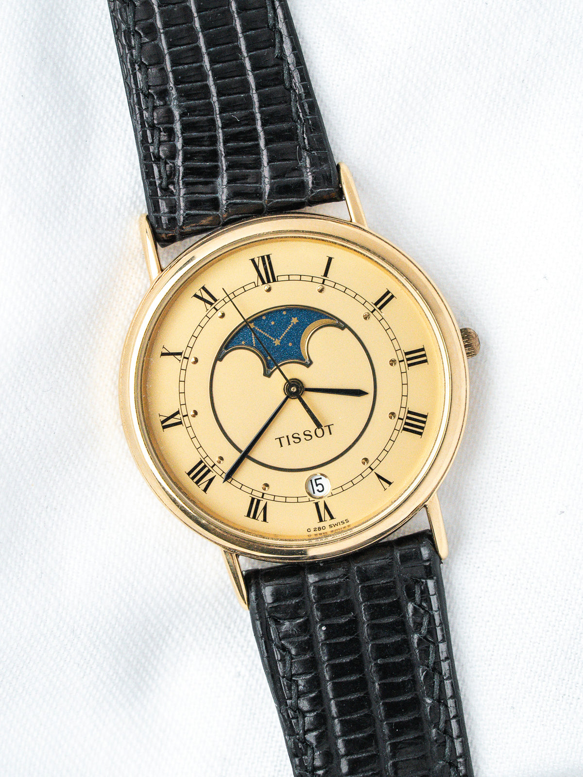 Tissot vintage watch with gold case, cream dial, moon phase, black leather strap