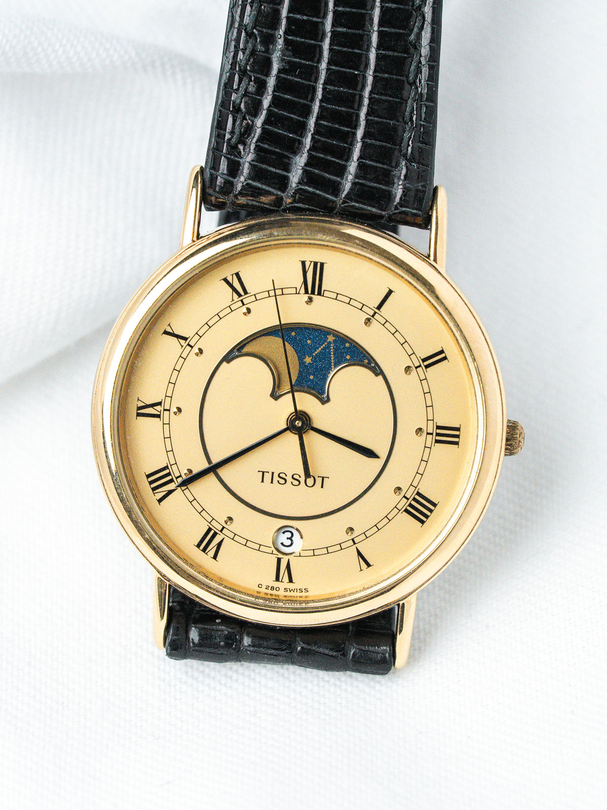 Tissot vintage watch with gold case, cream dial, moon phase, black leather strap