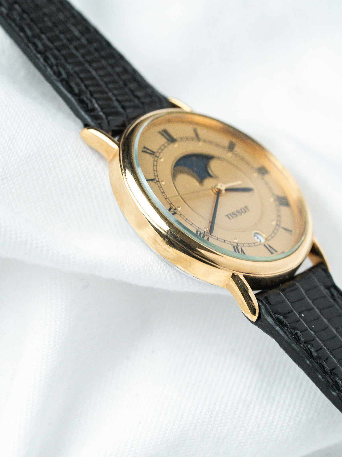Tissot vintage watch with gold case, cream dial, moon phase, black leather strap