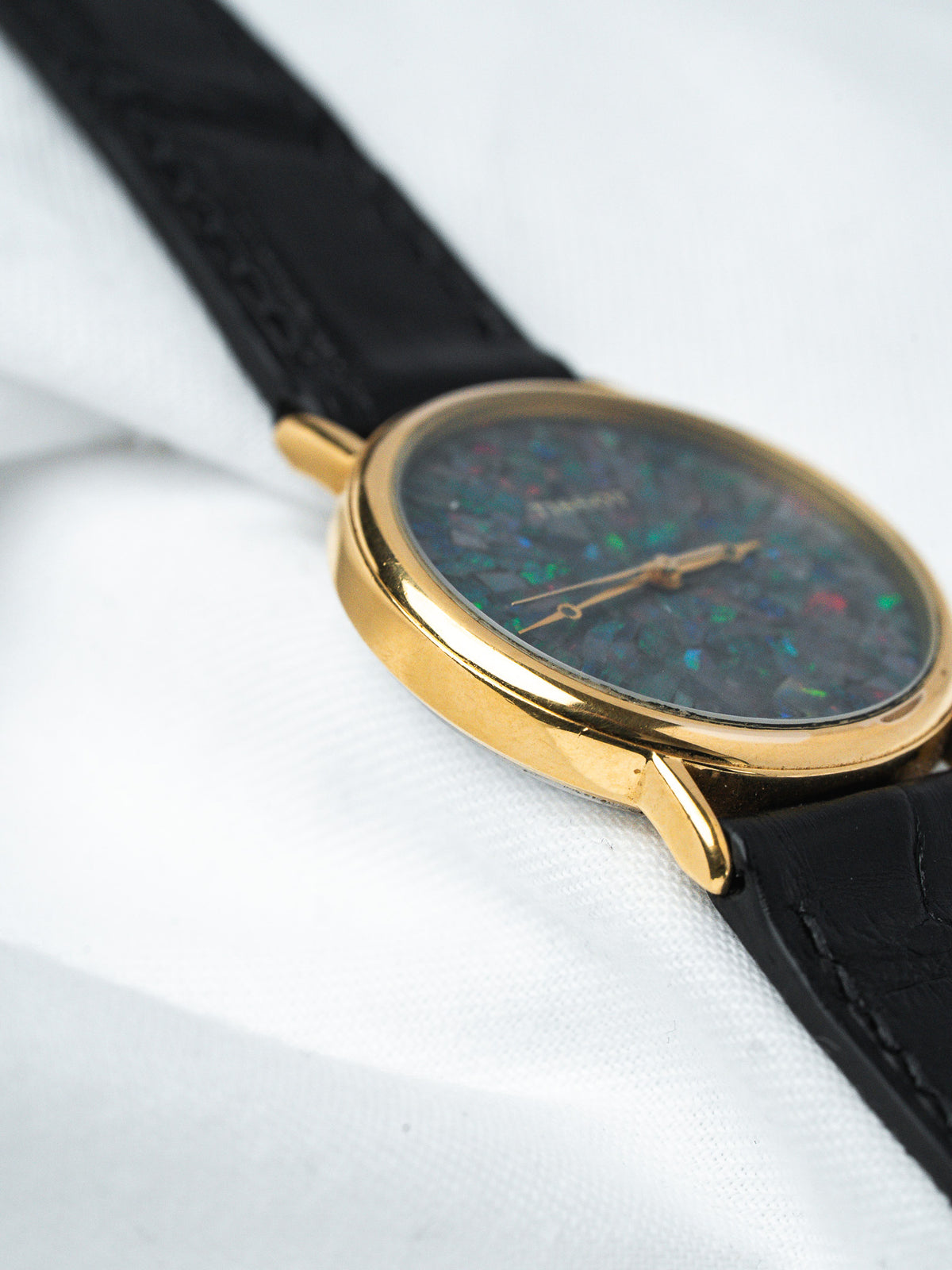 Montre vintage Universal Genève en or, cadran opale, bracelet cuir noir