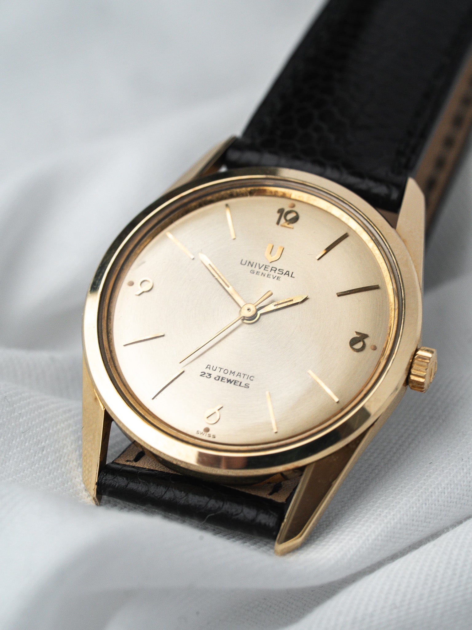 Universal Geneve vintage automatic watch with gold case, silver dial, black leather strap