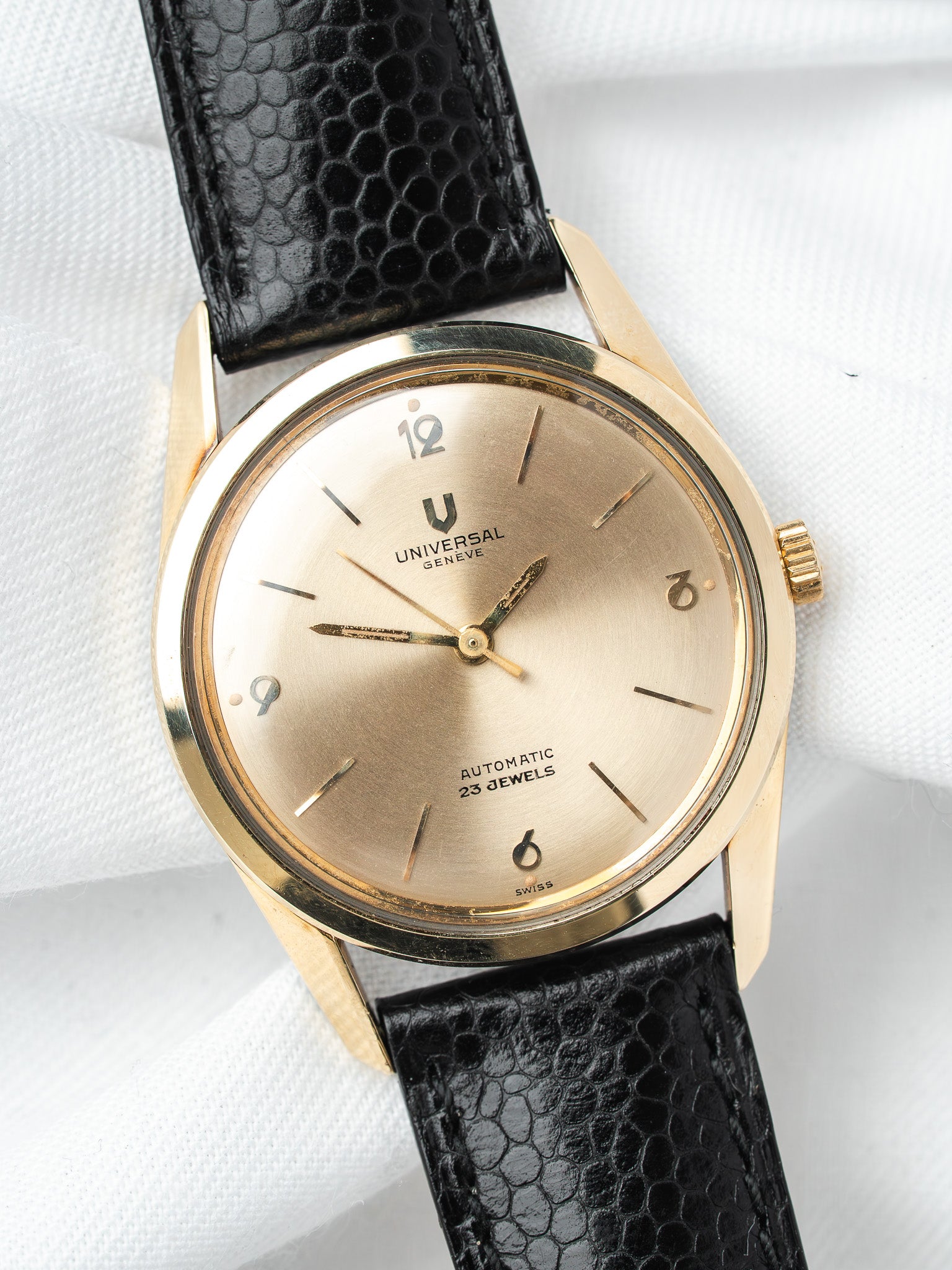 Universal Genève vintage watch with gold case, cream dial, black textured strap