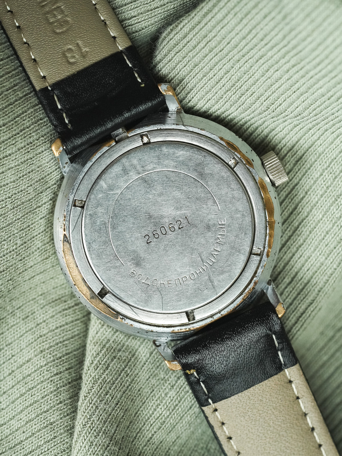 Vintage Vostok watch back with engraved serial number, steel case, black and beige strap