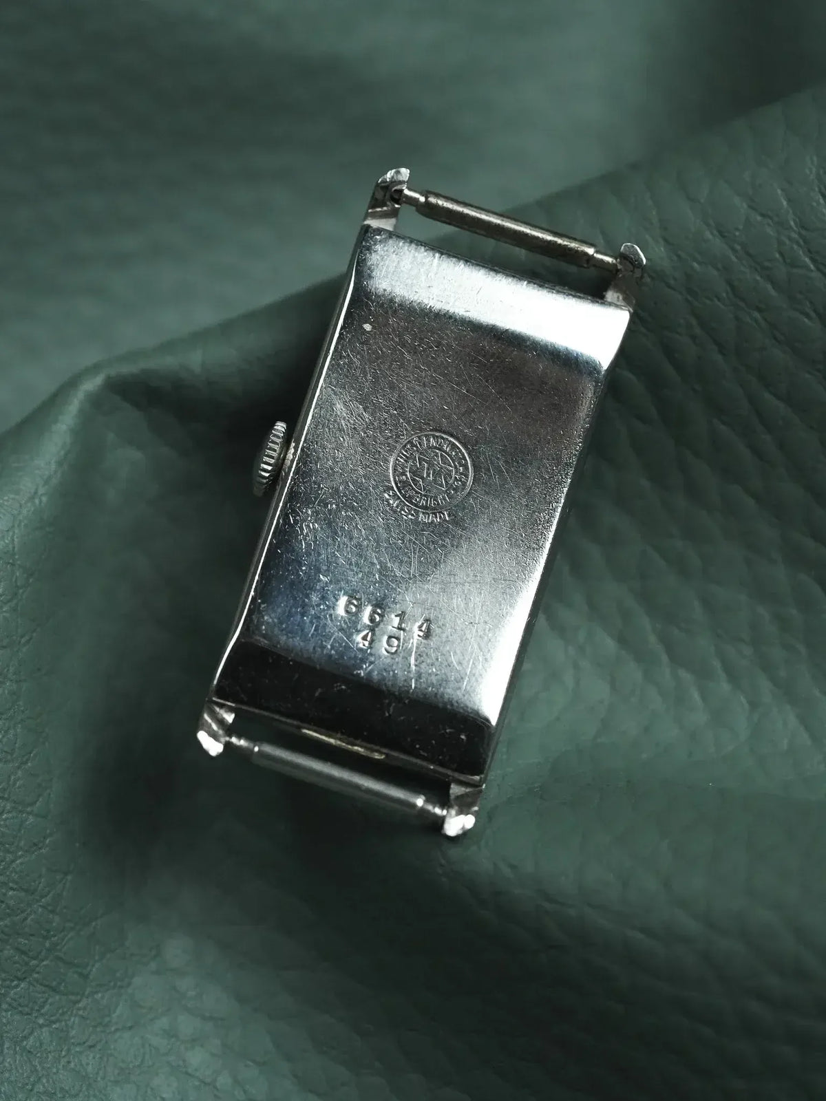 Vintage Universal Genève watch case back, stainless steel, engraved logo and numbers on green leather