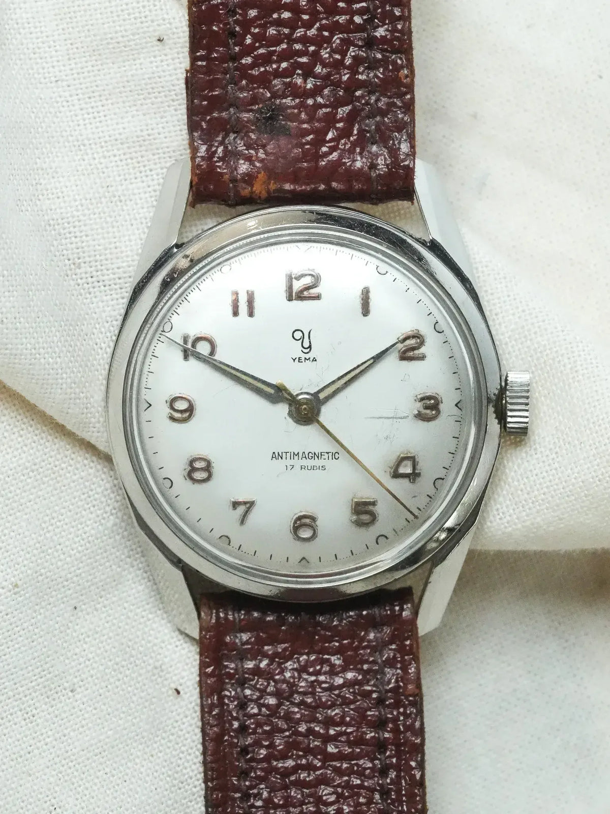 Vintage Yema antimagnetic watch with white dial, steel case, and brown leather strap