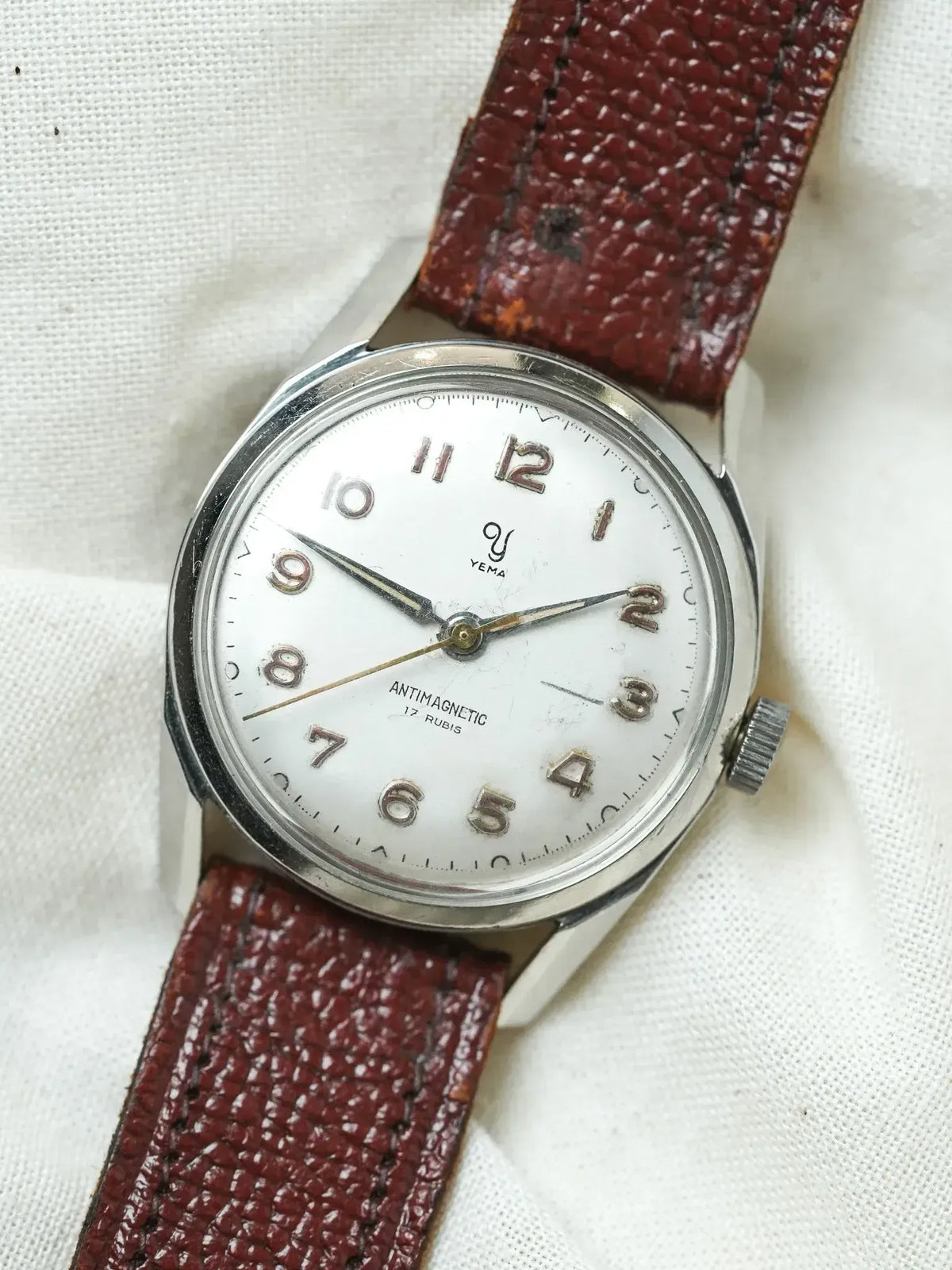 Vintage Yema watch with white dial, steel case, and brown leather strap