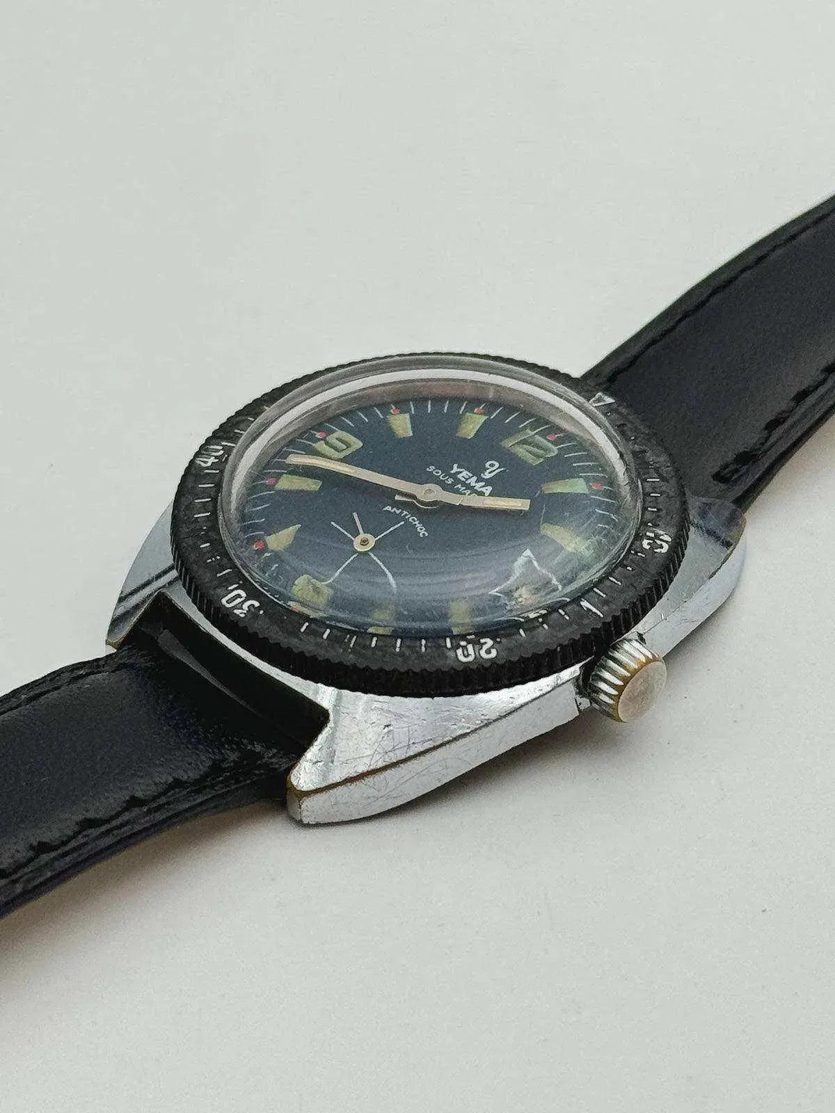 Vintage Yema Submarine watch with black dial, luminous markers, and black leather strap