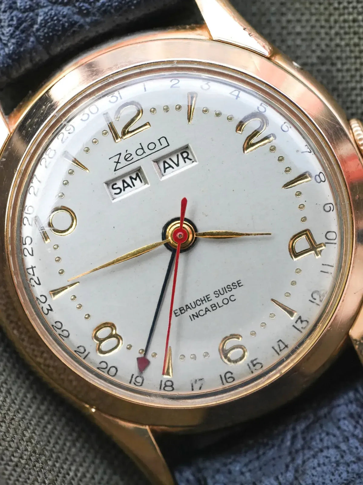 Zédon vintage watch with gold case, white dial, day-date display, and blue strap