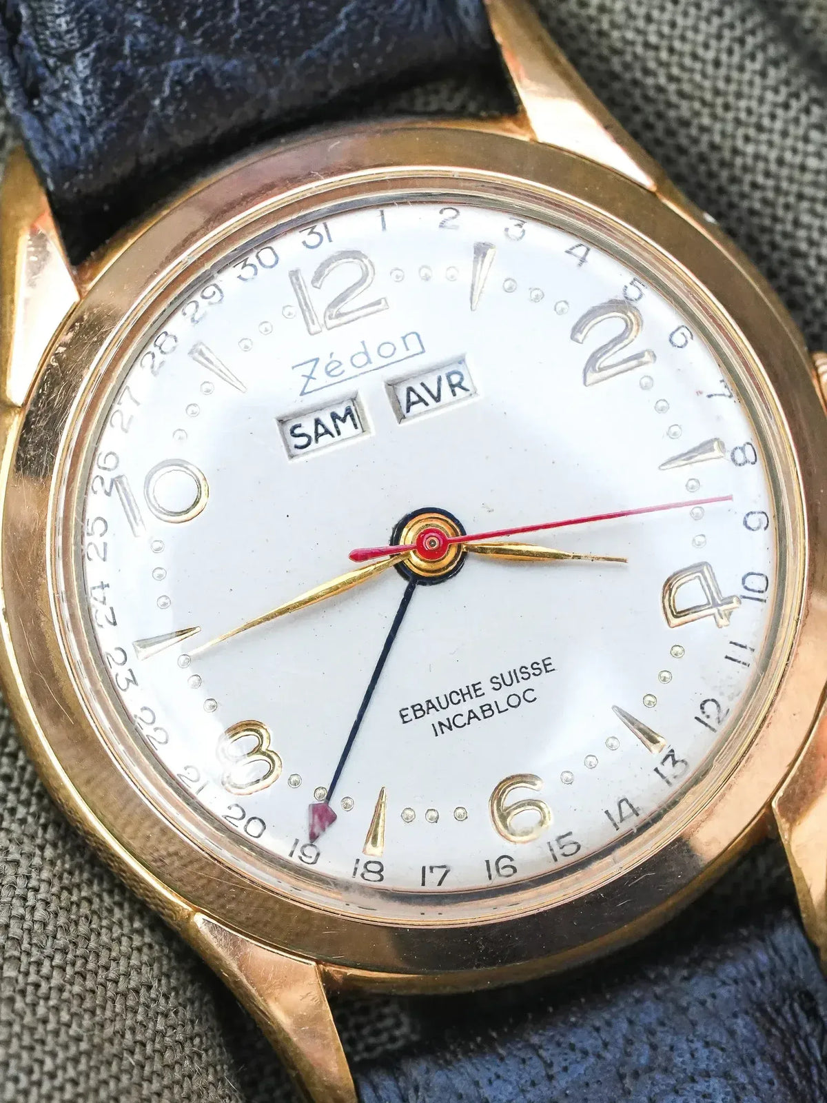 Zédon vintage watch with gold case, white dial, day-date, and blue leather strap
