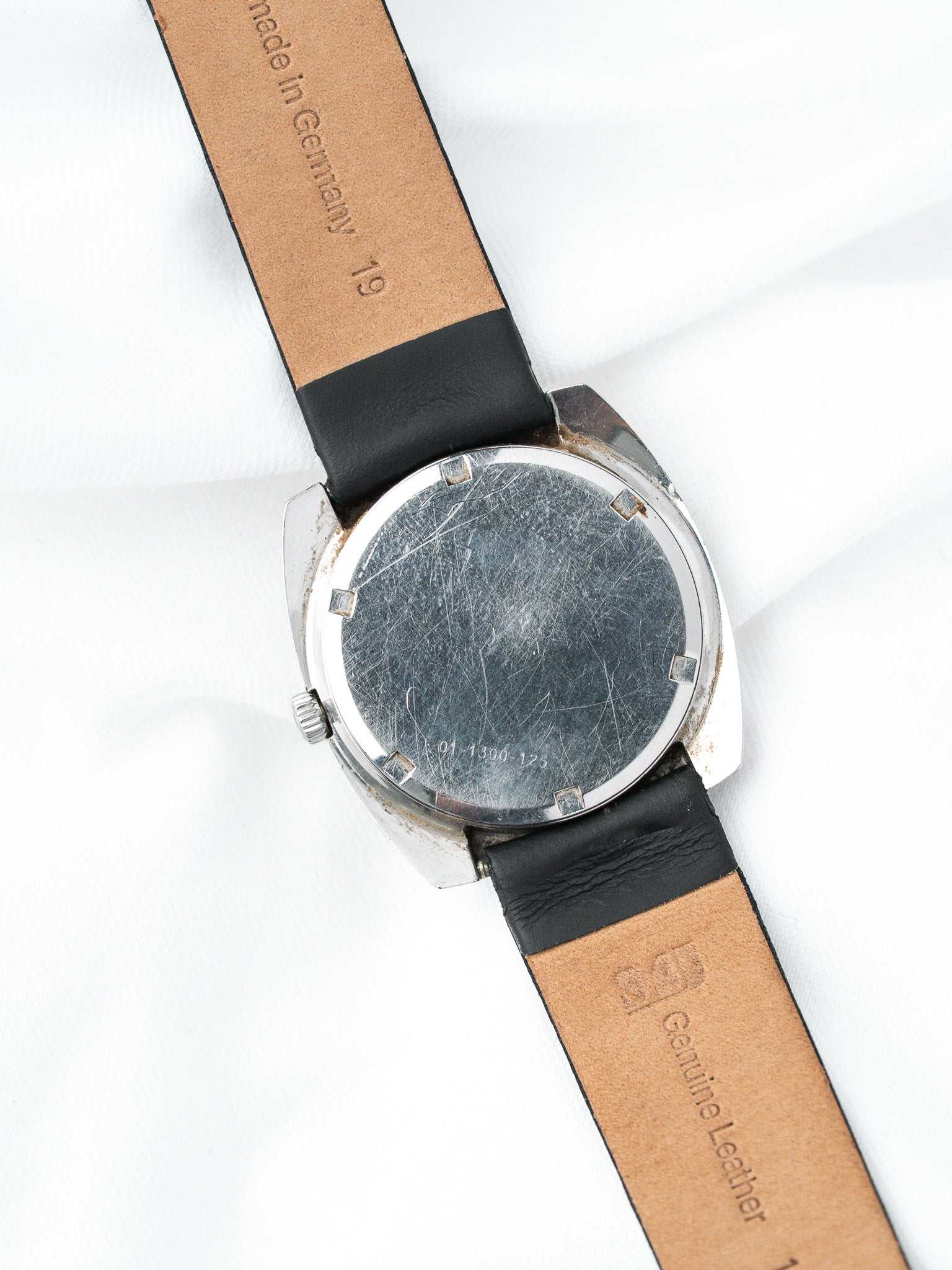 Vintage watch with scratched case back, black leather strap, made in Germany