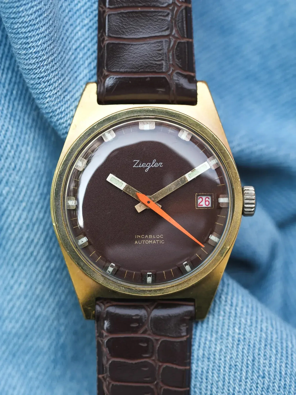 Ziegler vintage automatic watch with brown dial, gold case, and crocodile strap on denim