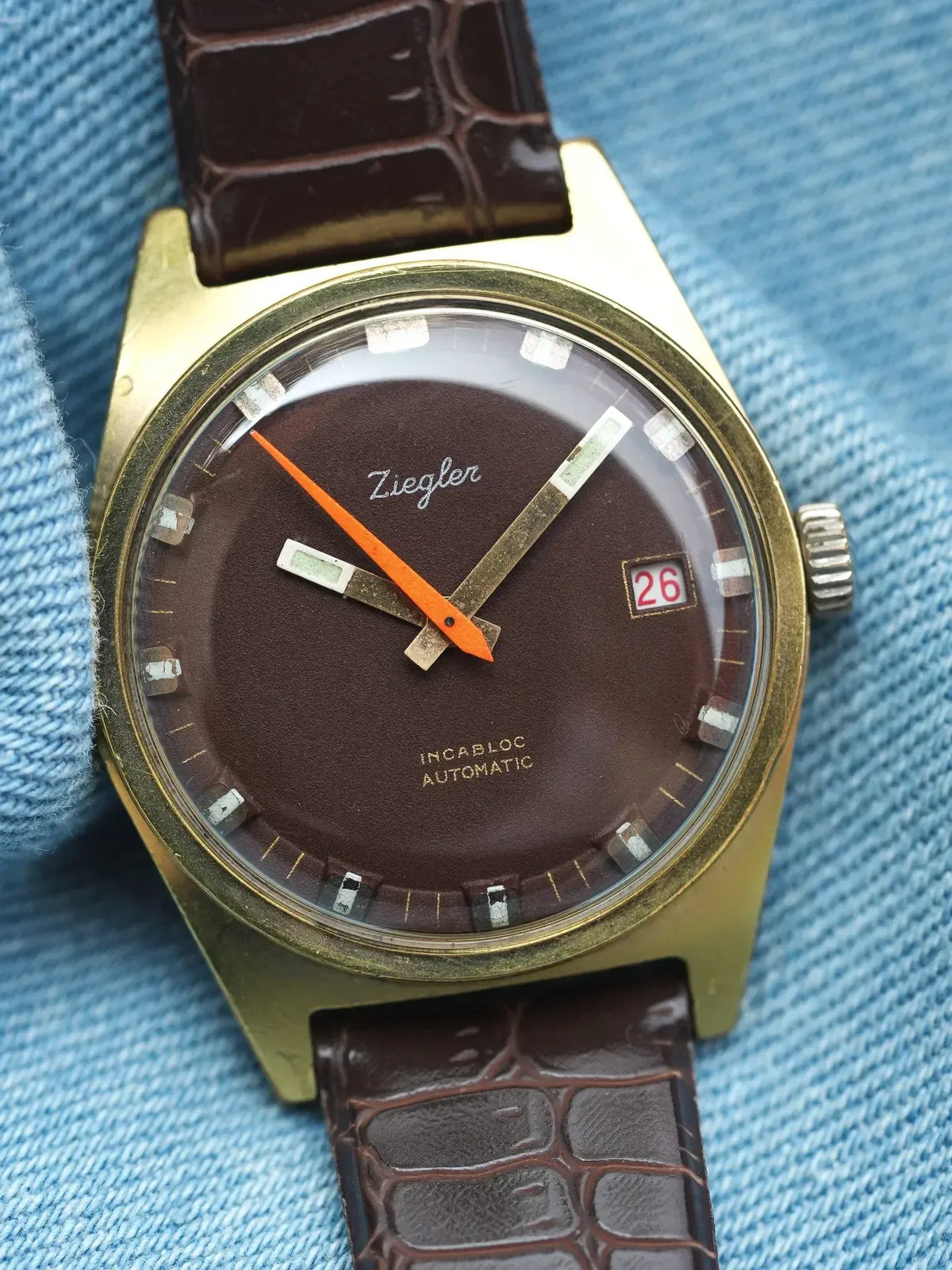 Ziegler vintage watch with brown dial, gold case, and crocodile strap on denim
