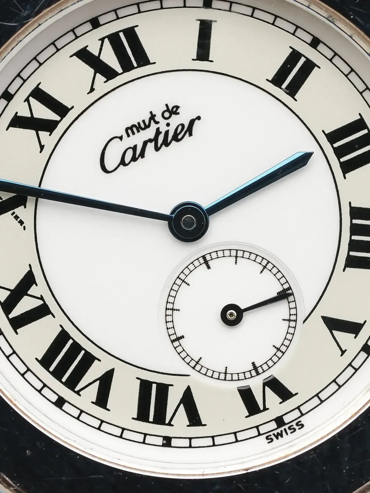Cartier vintage watch with white dial, black Roman numerals, and blue hands