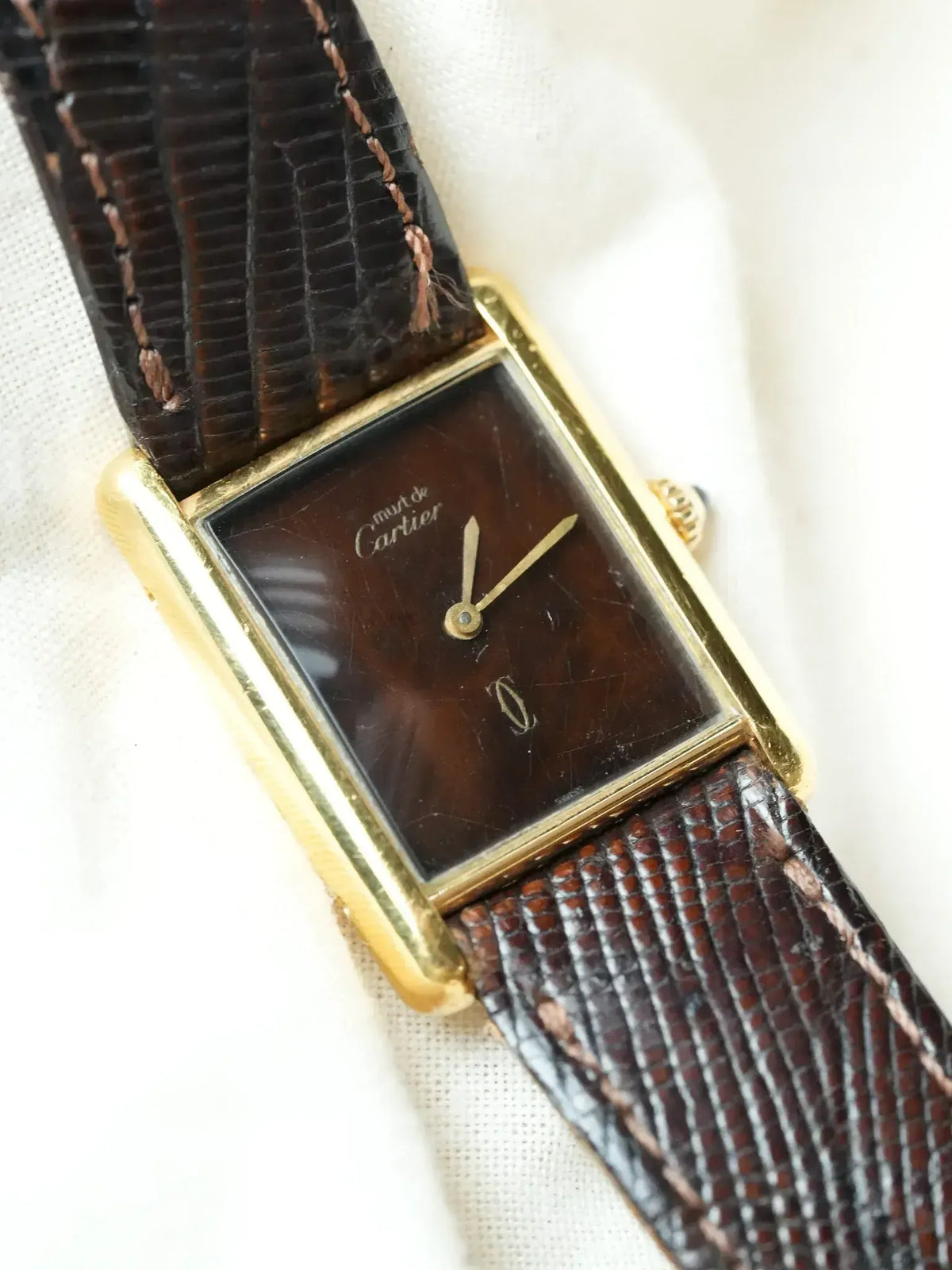 Cartier Must de Cartier vintage watch with gold case, brown dial, and textured strap