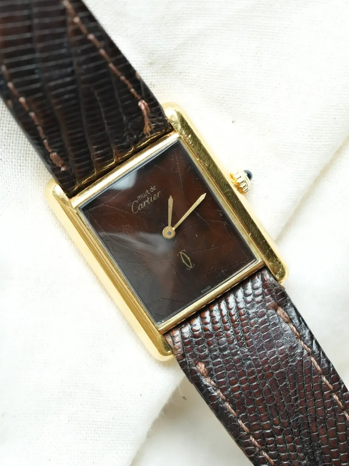 Cartier vintage watch with gold case, brown dial, and textured leather strap
