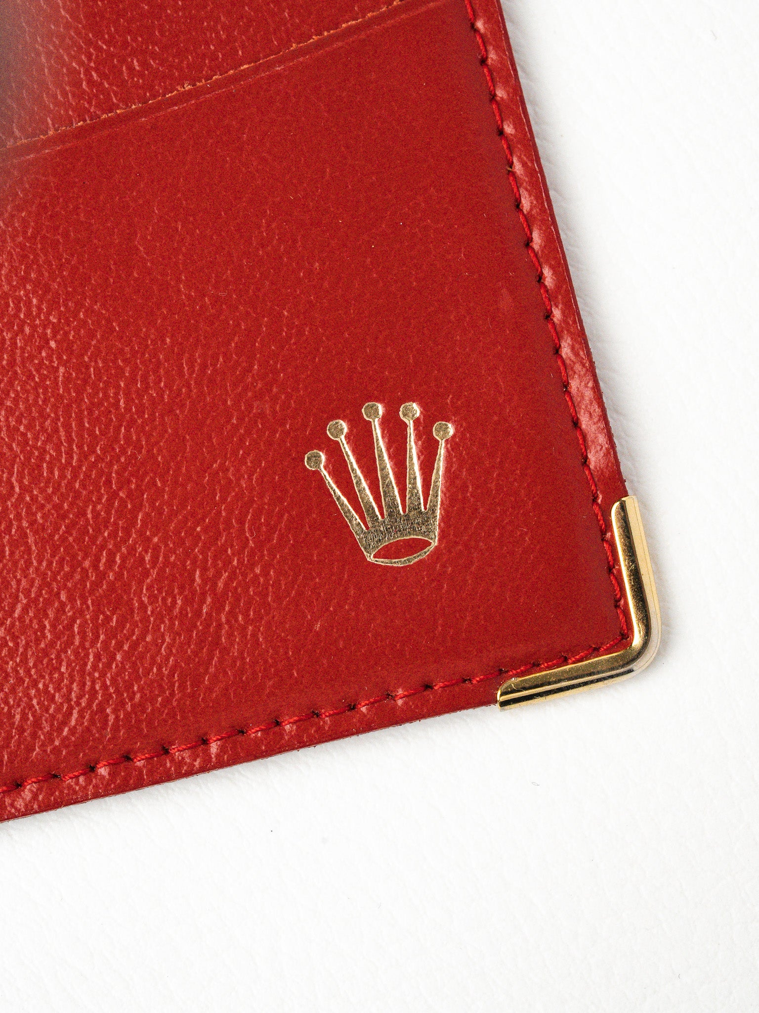 Red leather Rolex wallet with gold crown logo and corner protector