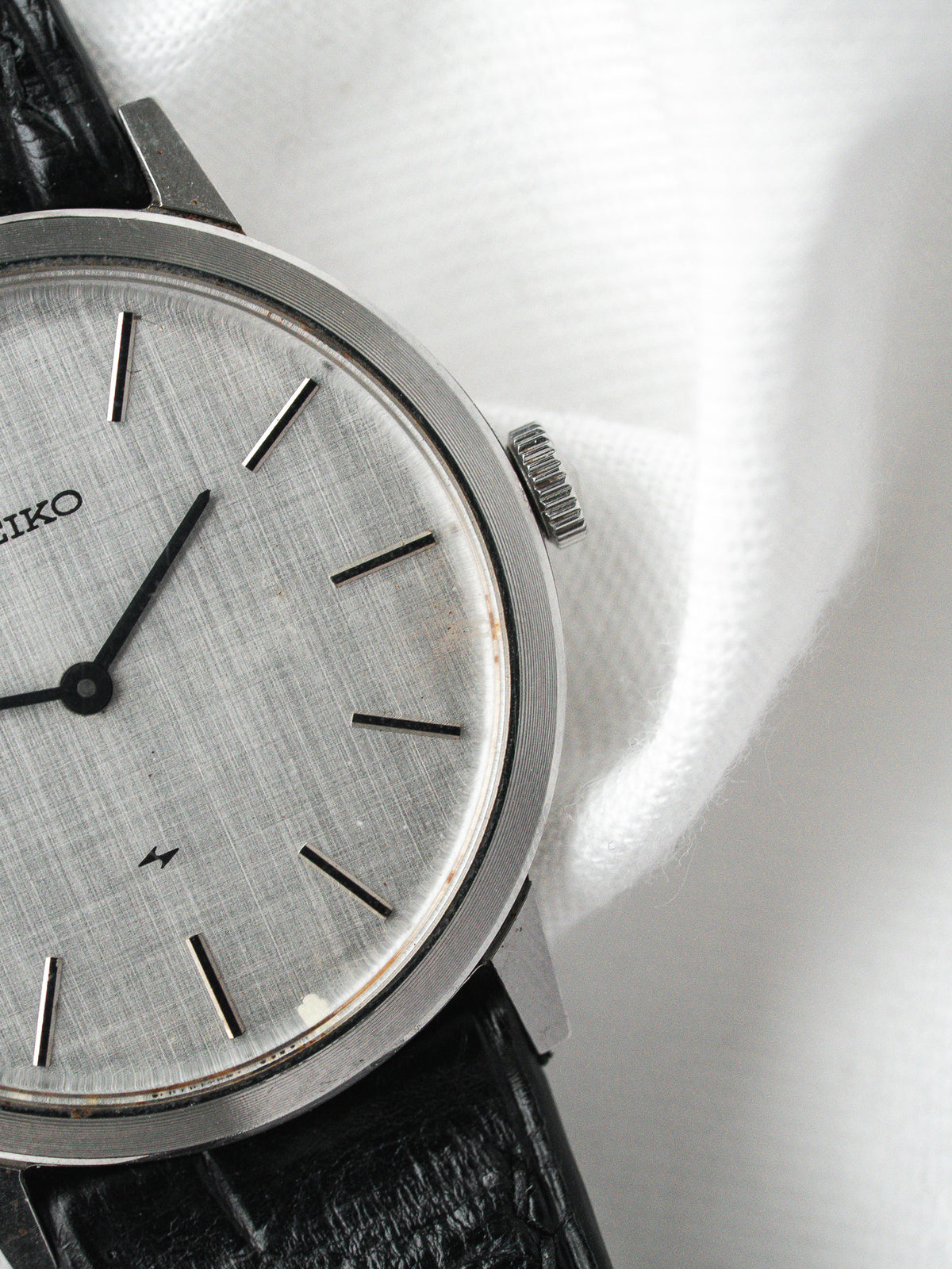 Seiko vintage watch with silver dial, black leather strap, and steel case