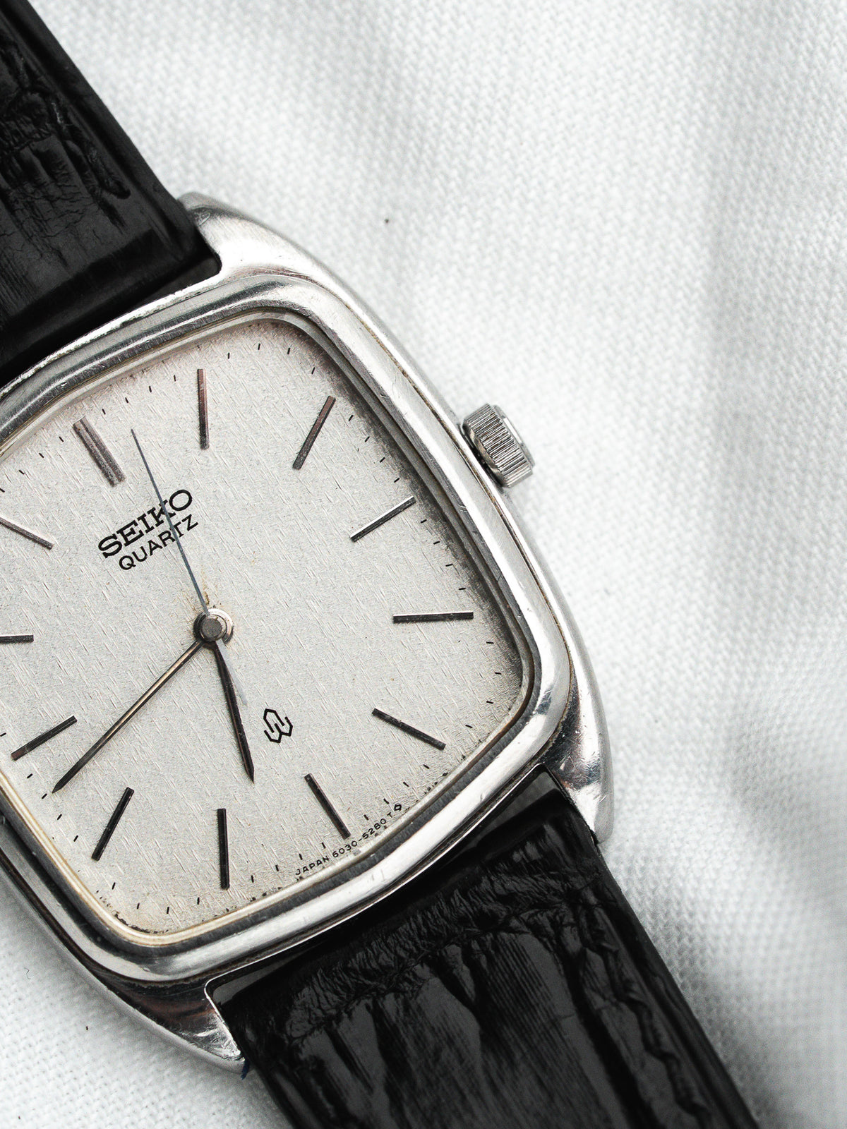Seiko Quartz vintage watch with silver dial, black leather strap, and steel case