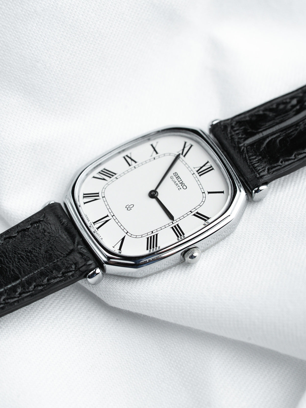 Seiko quartz vintage watch with white dial, Roman numerals, black leather strap