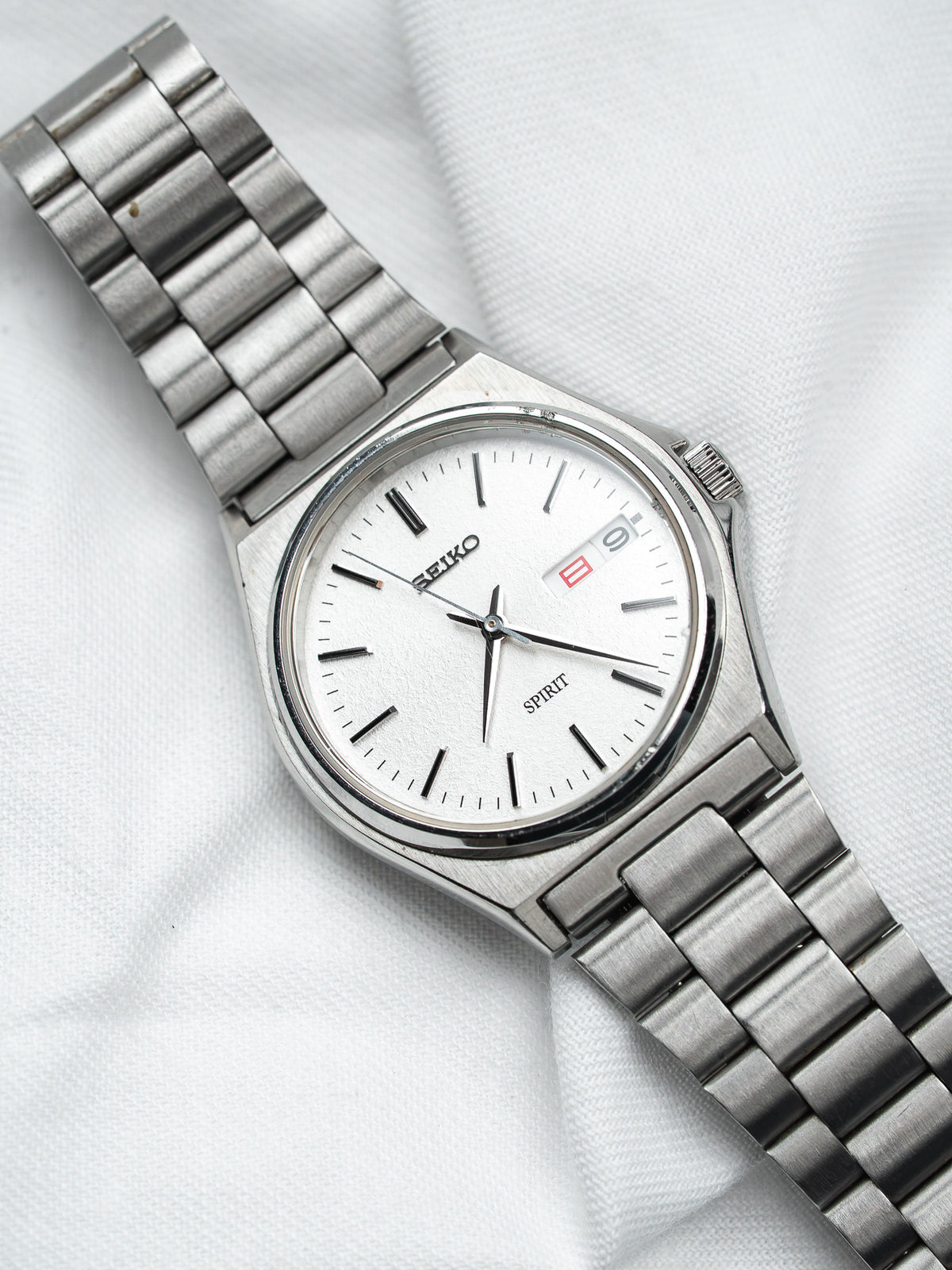 Seiko Spirit vintage watch with white dial, steel bracelet, and date display