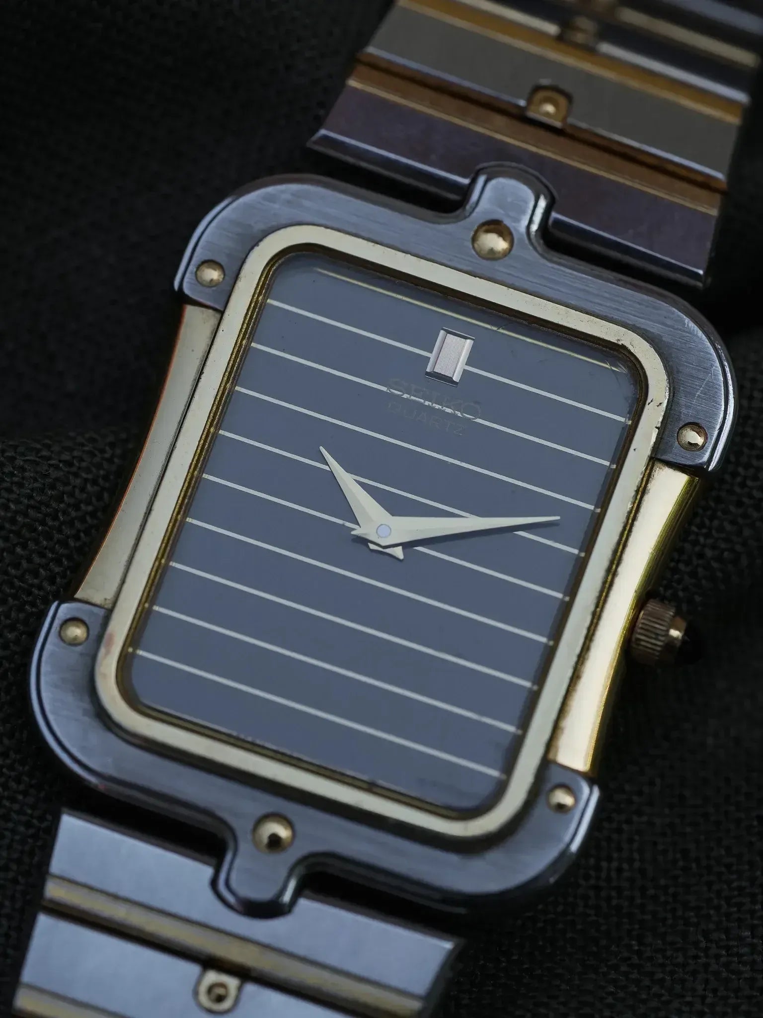 Seiko vintage watch with rectangular case, striped grey dial, and two-tone metal bracelet