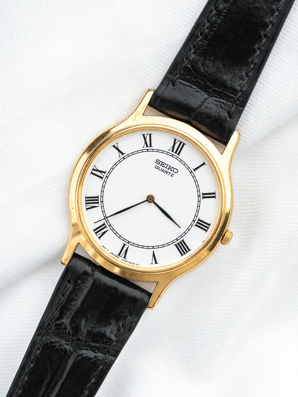 Seiko Quartz vintage watch with gold case, white dial, Roman numerals, black leather strap
