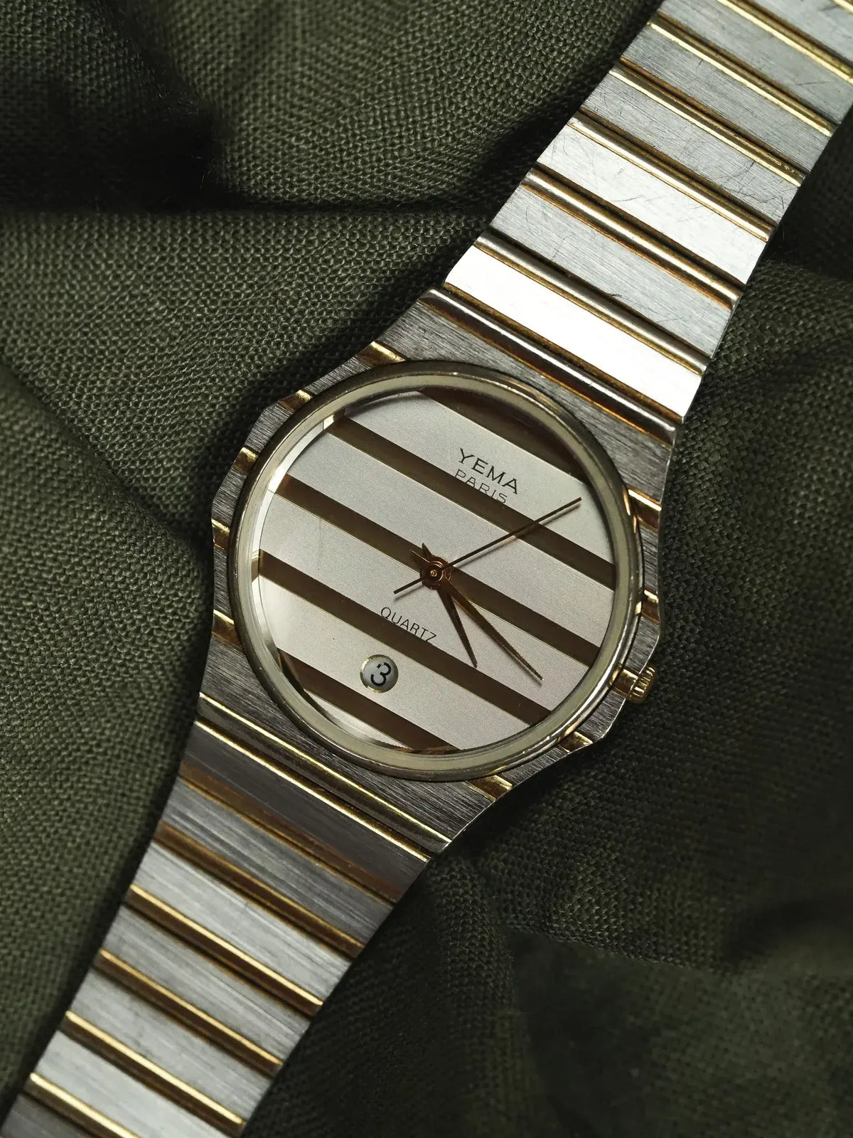 Yema Paris vintage quartz watch with striped dial and two-tone bracelet on fabric