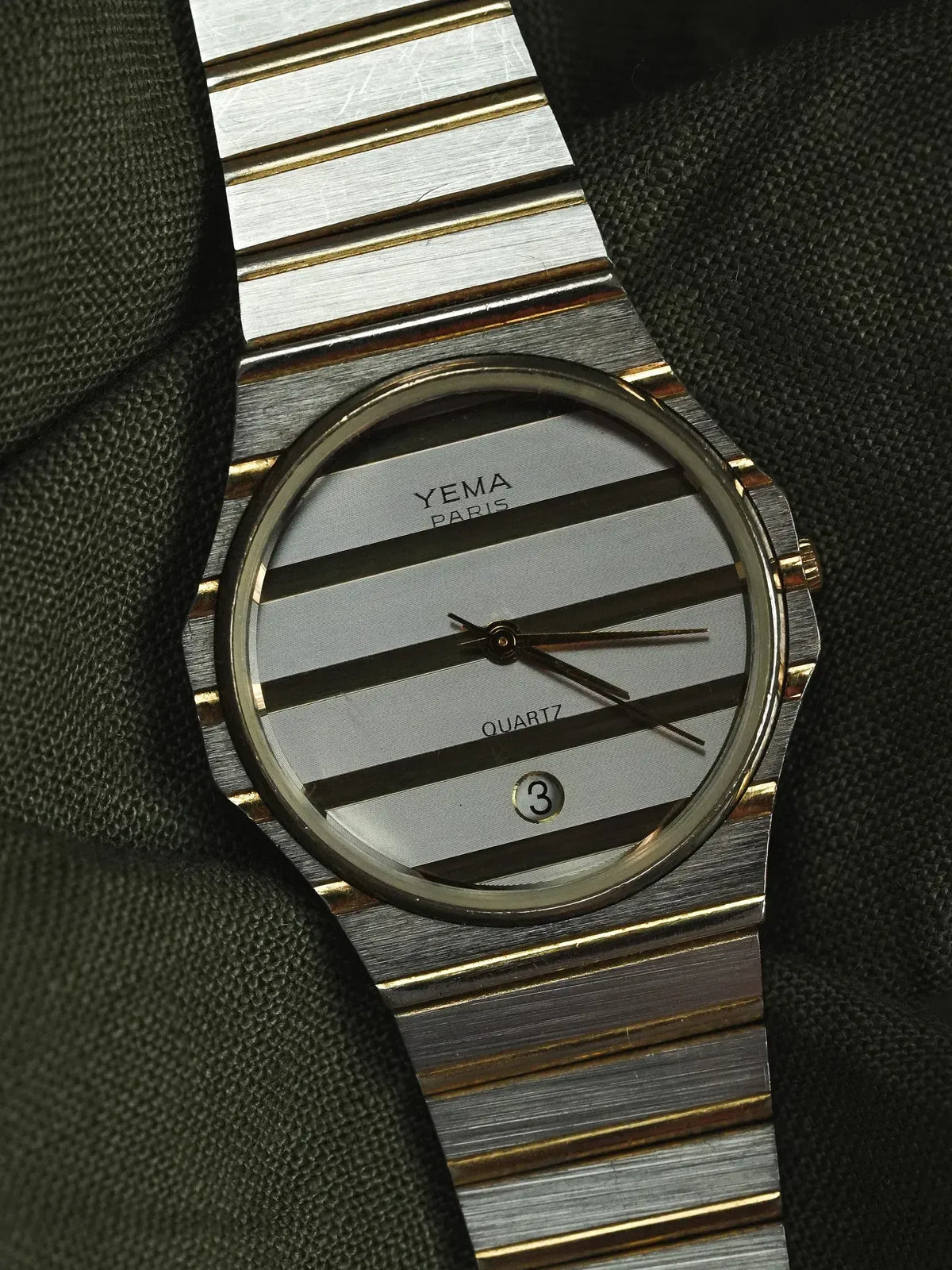Yema Paris vintage watch with striped silver dial, gold accents, and metal bracelet