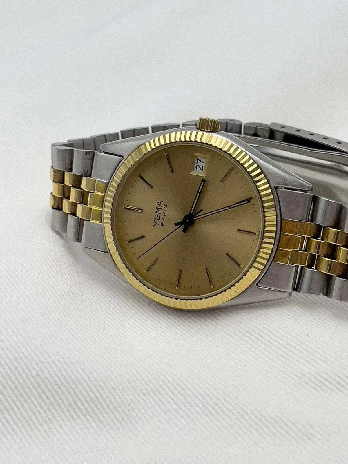YEMA Paris vintage watch with gold dial, two-tone bracelet, date window on white background