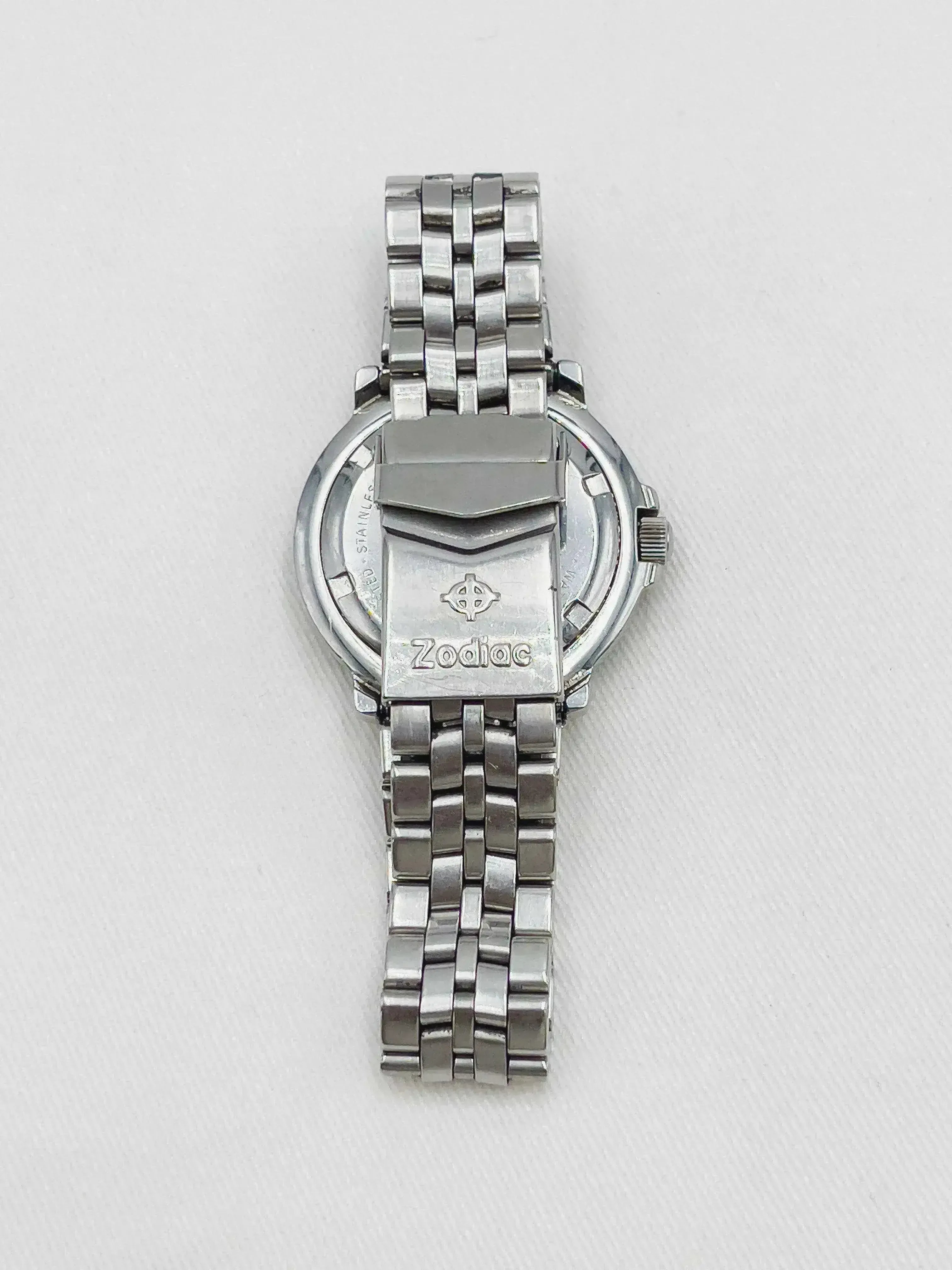 Zodiac vintage watch with stainless steel bracelet, case back visible on white background